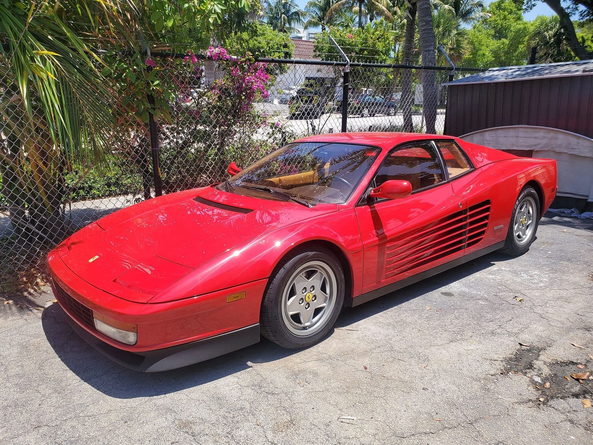 Red Ferrari Testarossa parked in the shop lot
